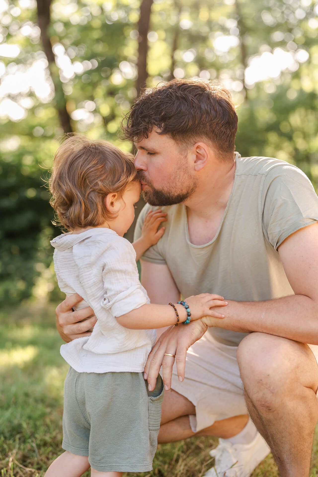 Papa gibt seinem kleinen Sohn einen Kuss auf die Stirn